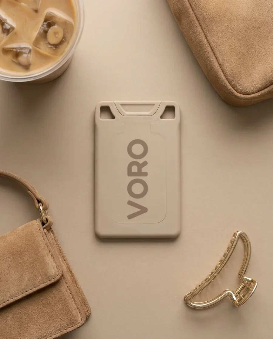 The Pistachio Shell VORO card on a tan field with an iced latte, suede, and a gold claw clip.