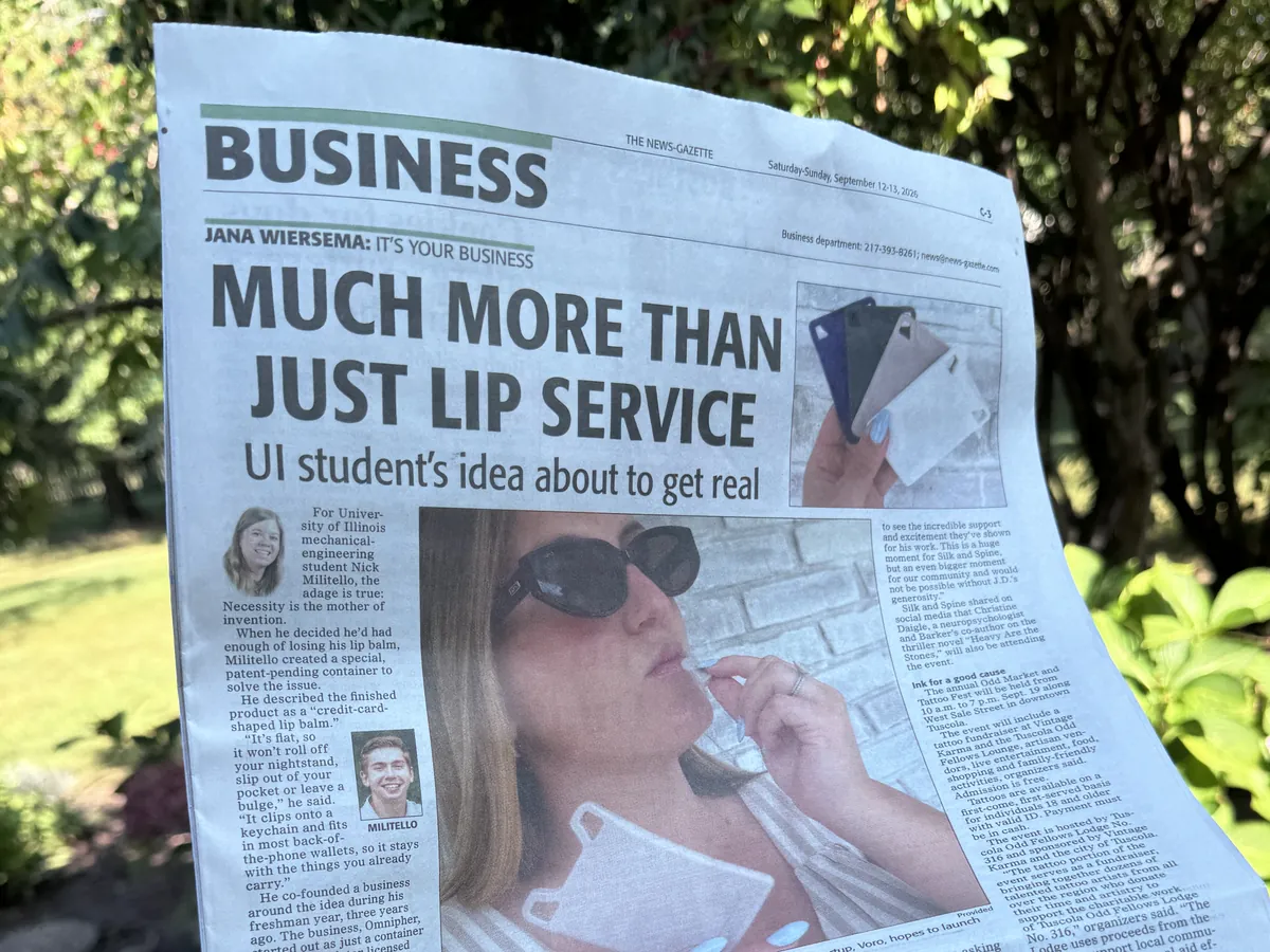 The News-Gazette business section held up outdoors, headlined Much More Than Just Lip Service, with a photo of VORO.