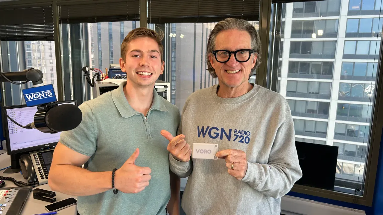 Nick Militello and the host in the WGN Radio 720 studio in Chicago, holding up a VORO card.